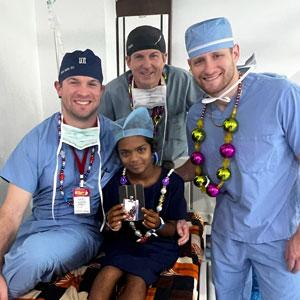 Jacob Taunton, DO with fellow doctors and young patient