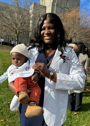 Ade Ojimi in her white coat holding her son