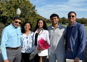 Netra Sivanandan in white coat posing with family members