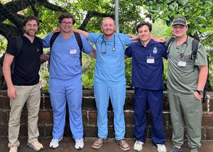 Carlos Jimenez, Jr. with students in scrubs smiling
