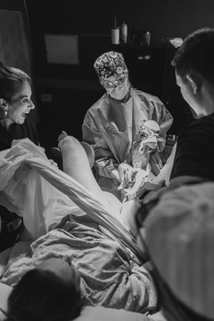 Dr. Mcinnis in a delivery room with newborn