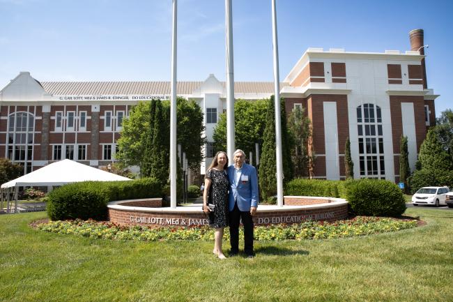 Gail Lott and James Edinger standing in front of the building displaying their name