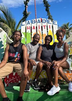 Shelda St. Preux with family sitting on a giant adirondack chair