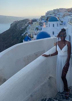 Shelda St. Preux standing on a balcony overlooking the ocean