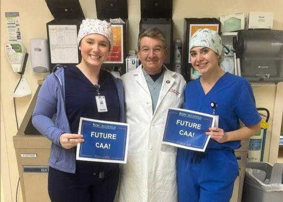 Two CAA students with a doctor smiling
