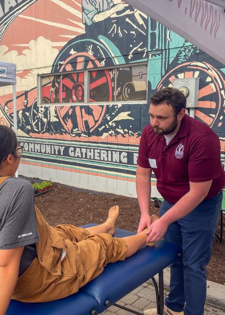 Medical student practicing OMM at Blacksburg's farmer's market