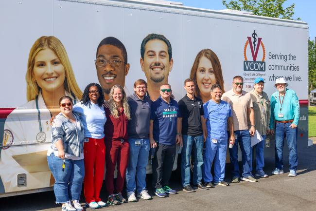 VCOM-Louisiana faculty and staff standing in front of a mobile medical unit