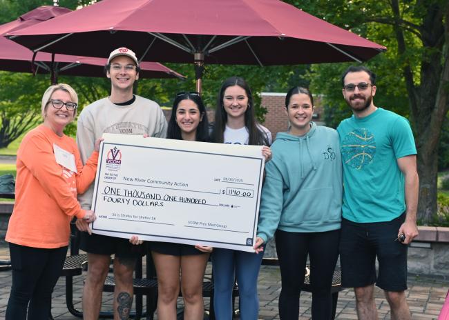 VCOM-Virginia students standing behind an oversized check for New River Community Action