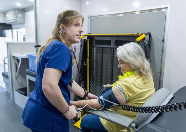 Holly Jarkzynka, OMS IV, checks the blood pressure of a senior attending the health fair 