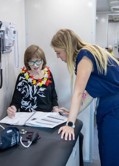 Savannah Collins, OMS IV, takes time to review and discuss blood pressure readings with Monroe senior Cathy Trichell during the mobile clinic visit 