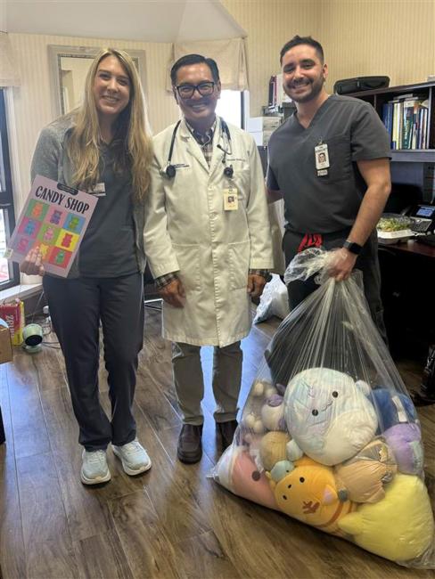 Doctor and medical students posing with a bag of children's toys