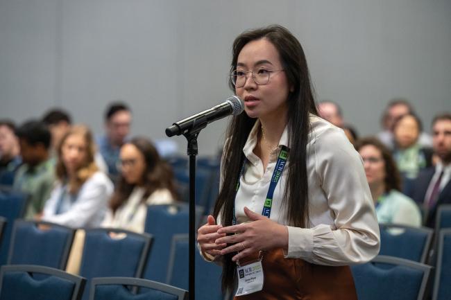 Annie Pham standing and speaking into a microphone