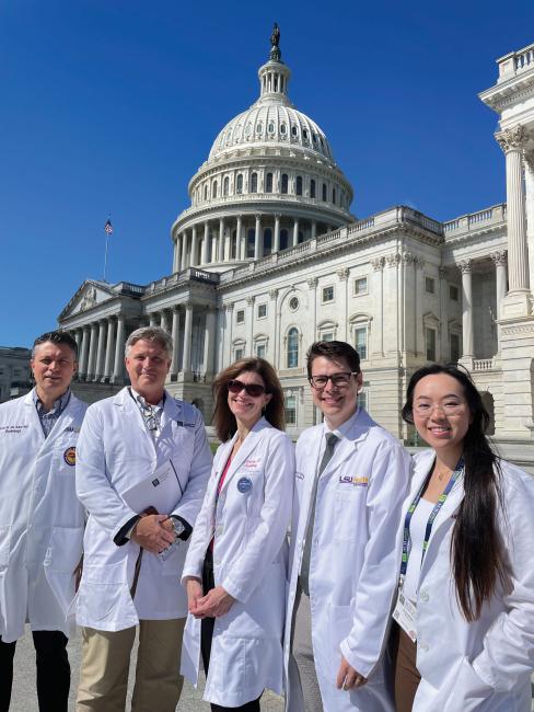 Annie Pham and others in white coats standing in front of the Capitol building in Washington, DC