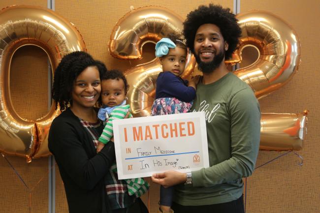 VCOM-Carolinas student with family holding up a match day sign