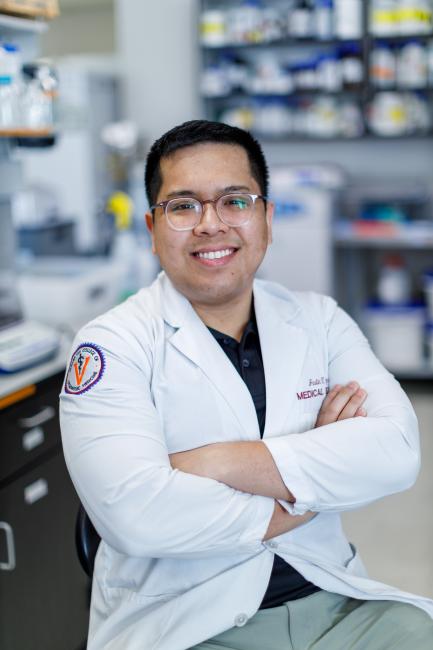 Justin Nguyen wearing a white coat smiling