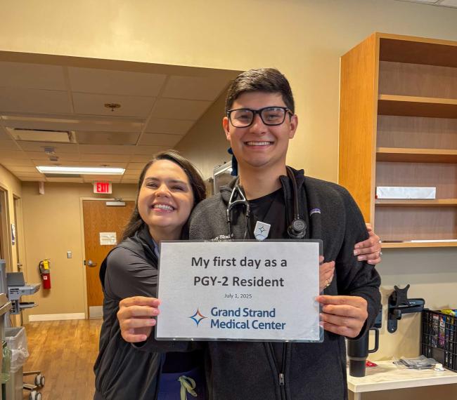 Trey Skains holding his PGY-2 resident sign