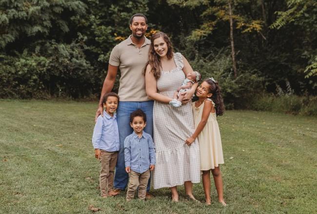 Jordan Saunders with his wife and children outside smiling