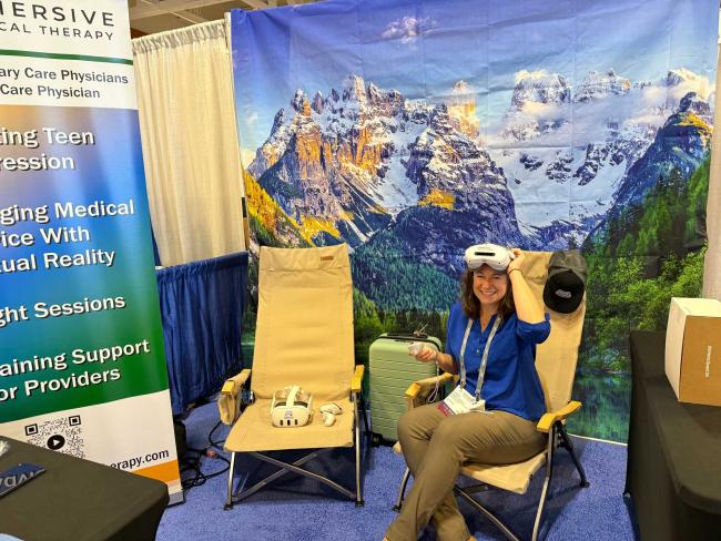 Lindsey Van Duyn wearing VR goggles sitting in a chair