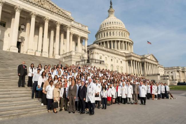 Large group of student doctors standing on the steps of the Capitol building
