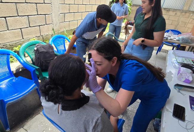 Student doctor examining a patient's eye