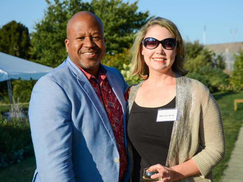 Alumni pose for a picture at a Homecoming garden party event.