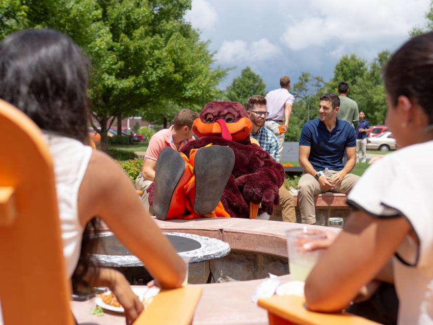 the Hokie Bird mascot poses with his feet up on VCOM campus