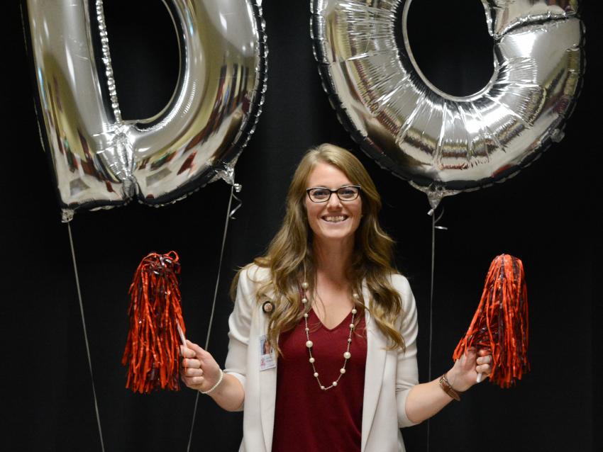 student services leader with pom poms at accepted students day