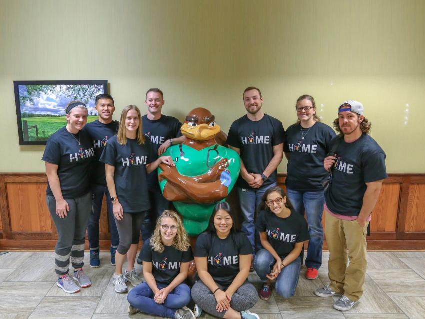 club members with hokie bird statue