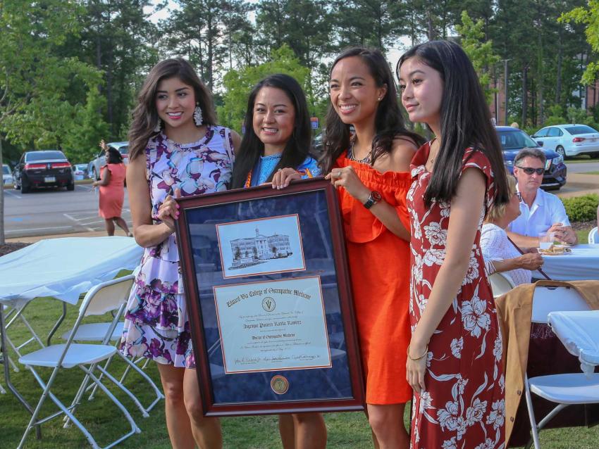 Student holding diploma - Auburn Campus