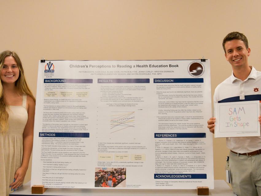 VCOM Auburn students standing in front of research poster