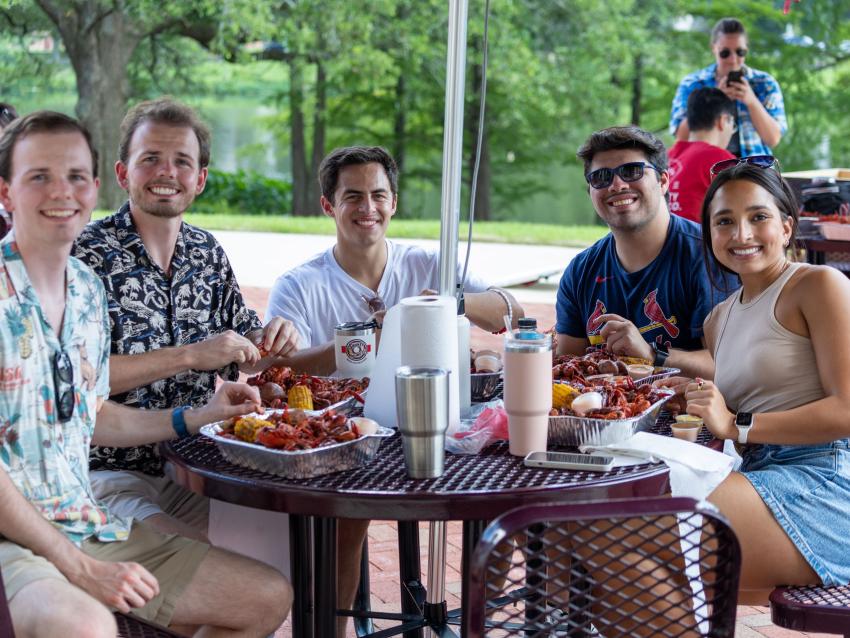 Students gathered at a table during a picnic