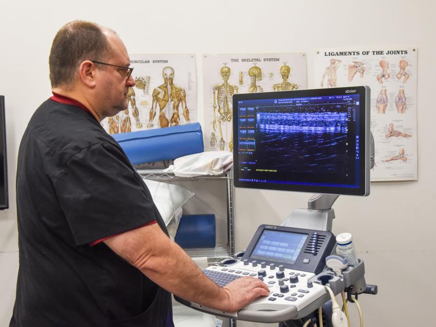 Dr. Kozar looking at the screen of an ultrasound machine