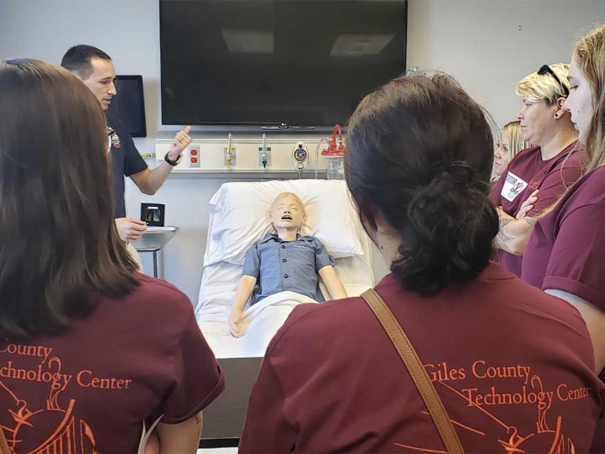 High school students gathered in a simulation center room