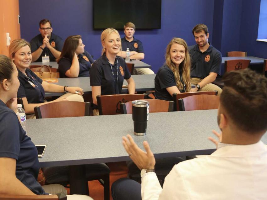 Small group of students in a classroom talking
