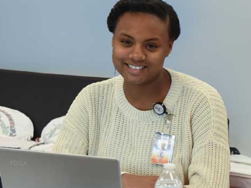 Woman smiling while working with laptop