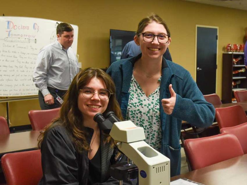 Two MABS students working with a microscope