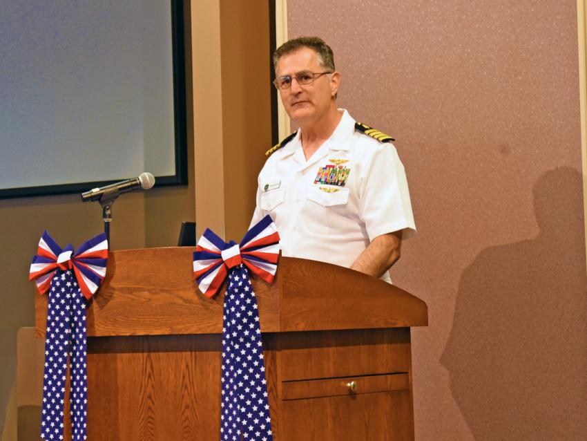 Captain Kris Belland, DO, MPH, MC, US Navy (Retired) addresses the attendees of VCOM-Virginia 2024 military promotion ceremony