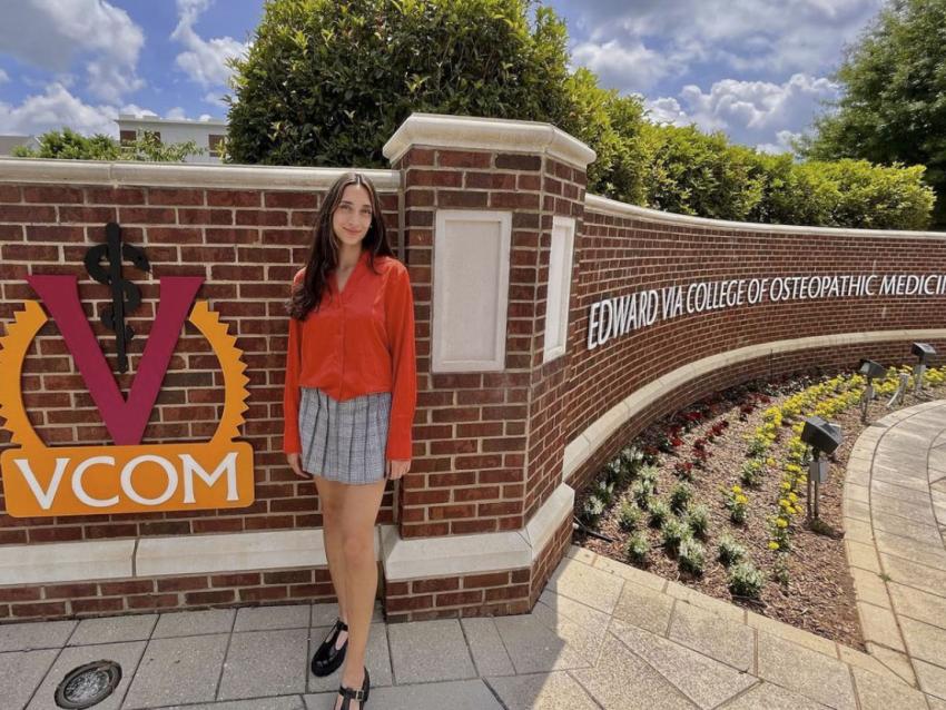 Faith Baxter standing in front of VCOM Carolinas entrance