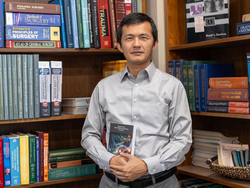 Lin Kang, PhD. holding his book "Inner Logic of Life: Understanding the Origins and Evolution of Life from the Perspective of Complex System"