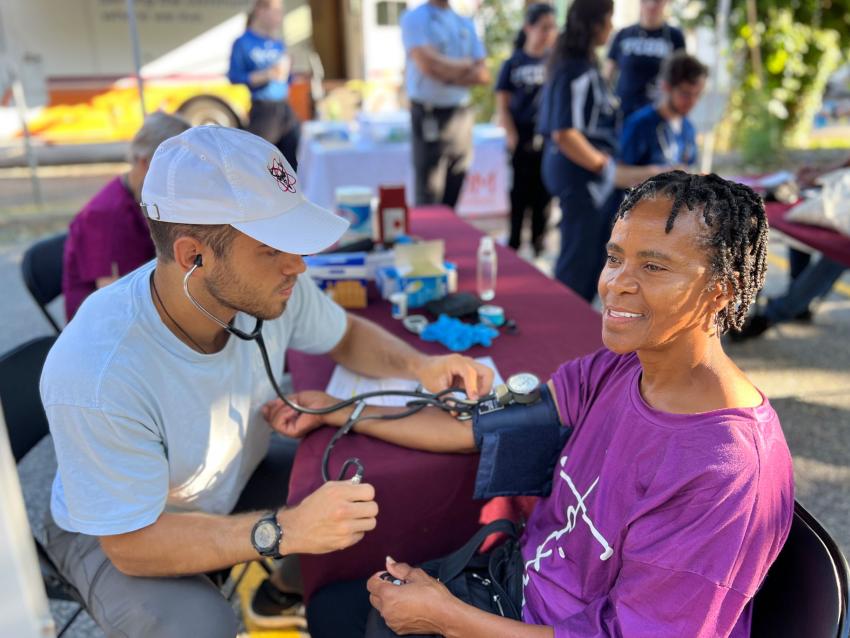 Medical student taking a blood pressure reading on a patient