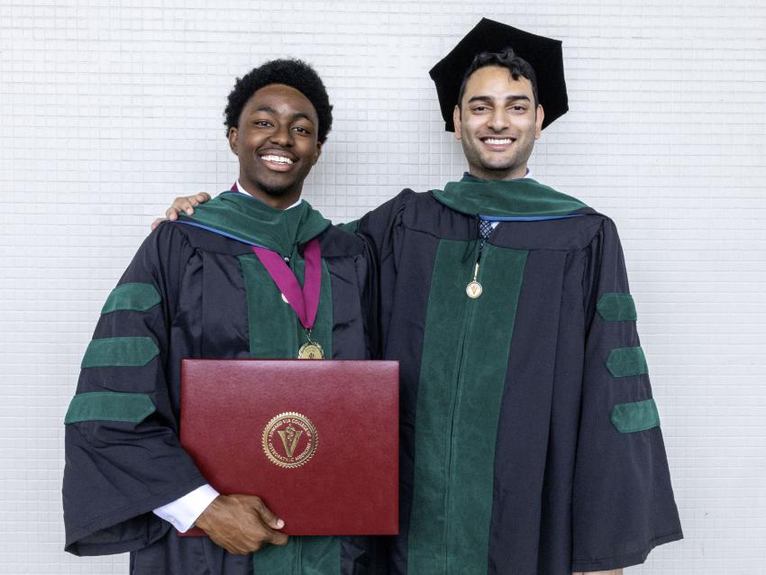 Two VCOM-Louisiana graduates in regalia smiling