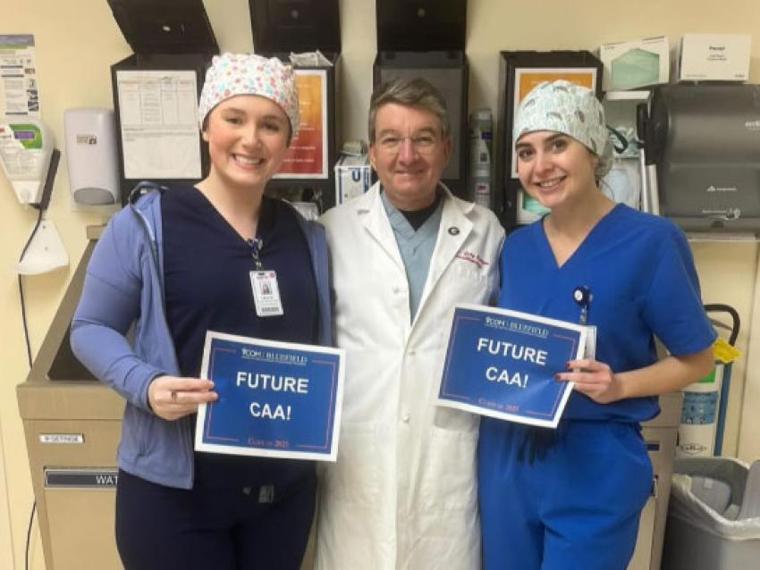 Two CAA students with a doctor smiling