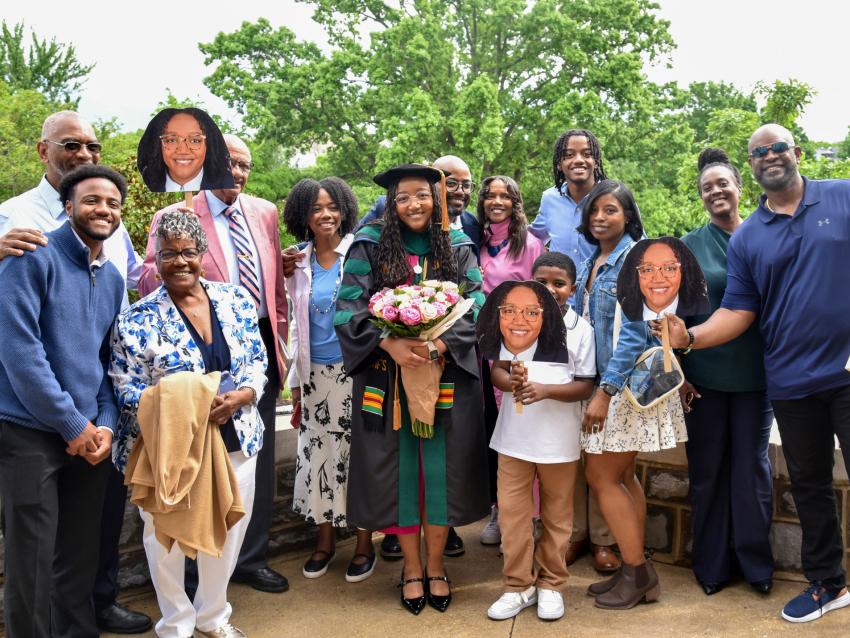 VCOM-Virginia class of 2025 graduate holding flowers and posing with her happy family