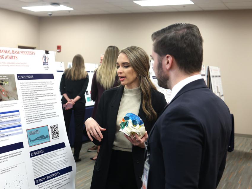 VCOM-Auburn student speaking about her research day poster