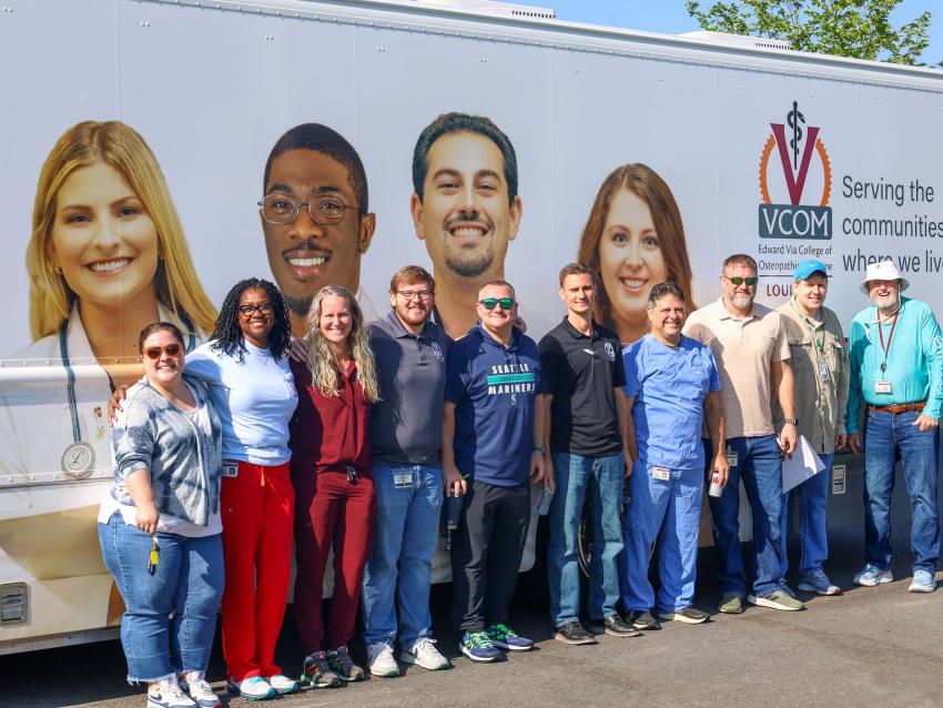 VCOM-Louisiana faculty and staff standing in front of a mobile medical unit