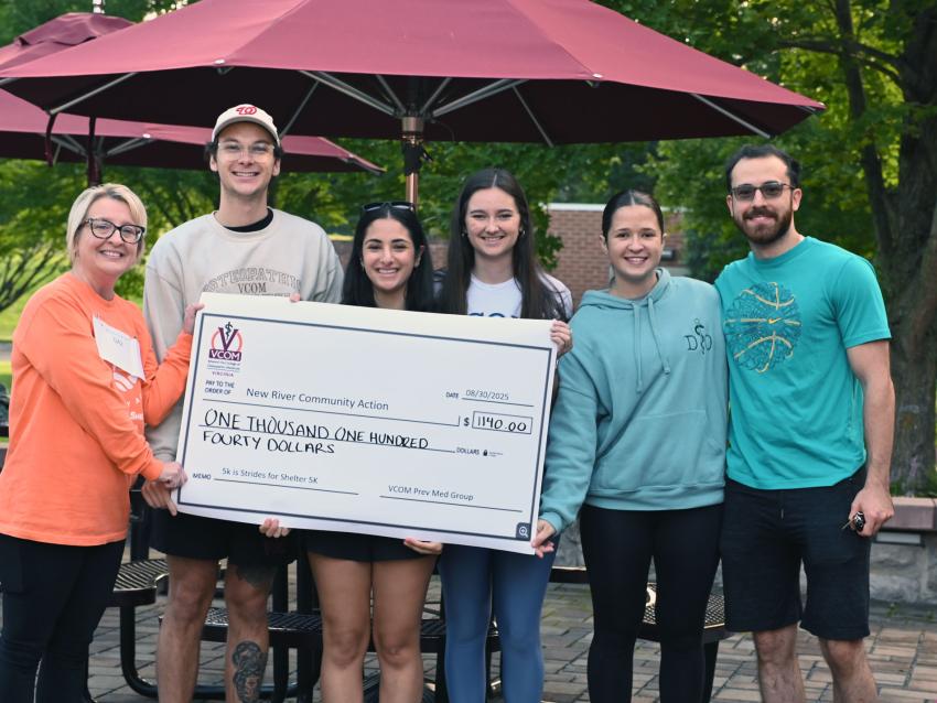 VCOM-Virginia students standing behind an oversized check for New River Community Action