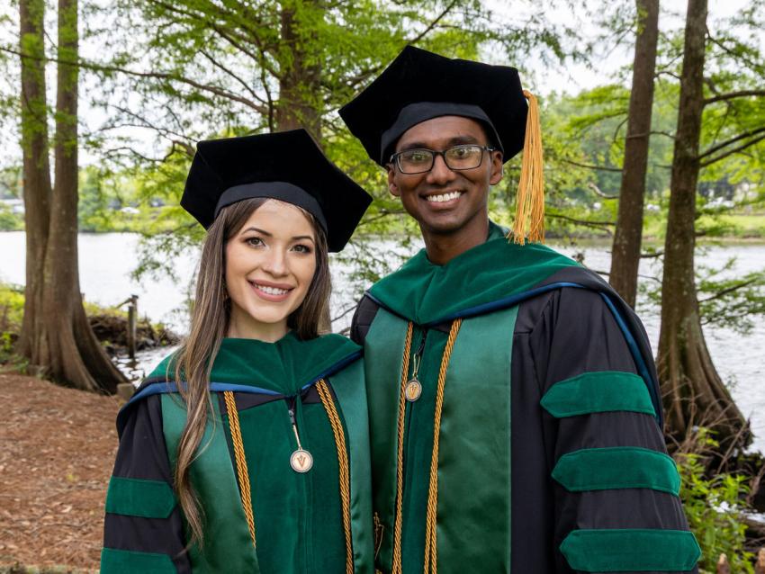 Two VCOM-Louisiana graduates in regalia smiling