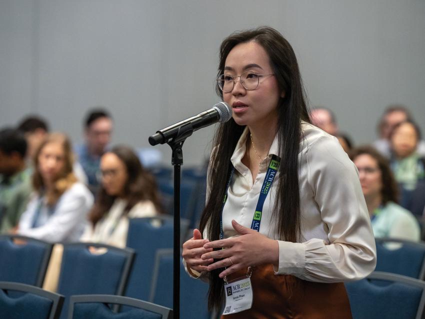 Annie Pham standing and speaking into a microphone