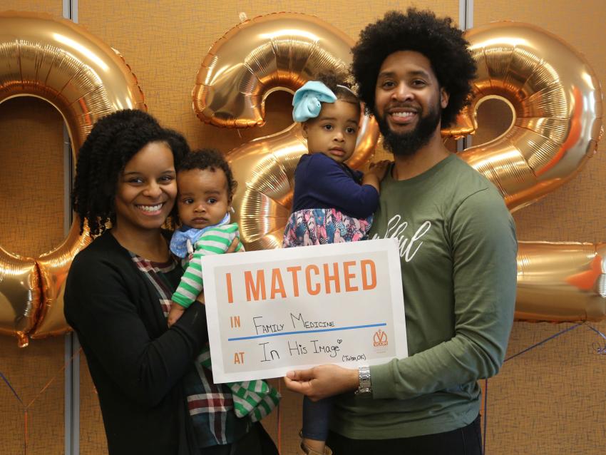 VCOM-Carolinas student with family holding up a match day sign