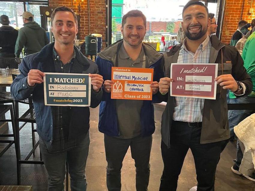 VCOM-Carolinas students holding up their match day signs